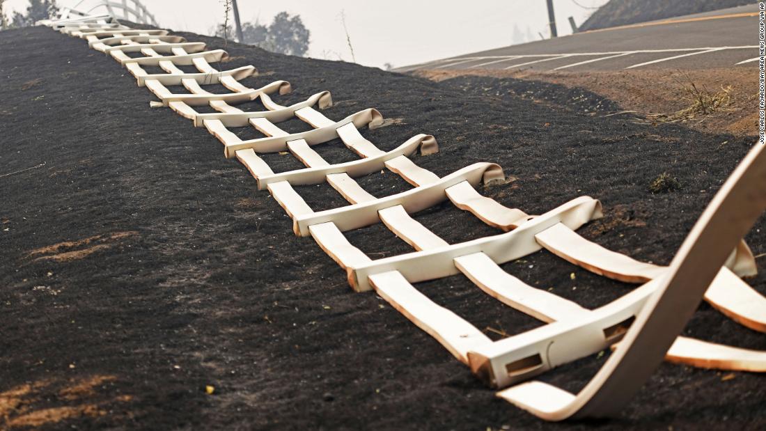 A melted plastic fence lies on the charred ground after fire swept through Vacaville on August 20, 2020.