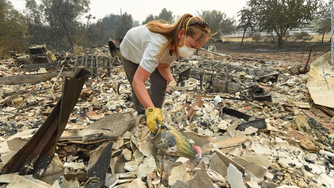 Sarah Hawkins searches through rubble after her Vacaville home was destroyed on August 20, 2020.