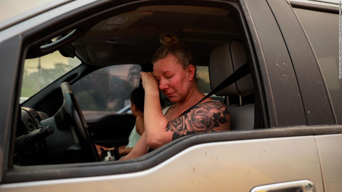 Gina Santos cries in her car after evacuating Vacaville on August 19, 2020.