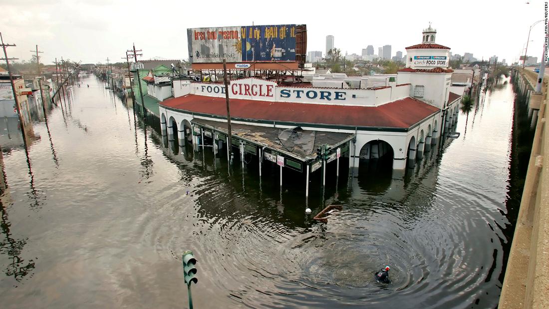 A man swims by the Circle Food Store in flooded New Orleans.