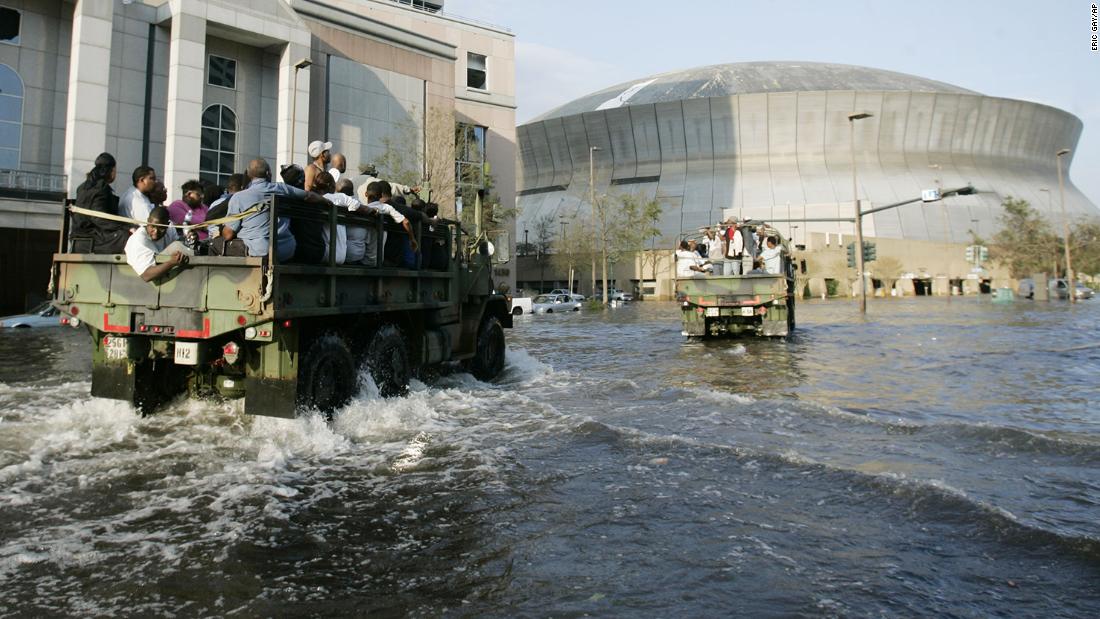 National Guard trucks haul displaced New Orleans residents to the Superdome a day after the hurricane flooded their neighborhoods. About 25,000 evacuees were sheltered at the stadium.
