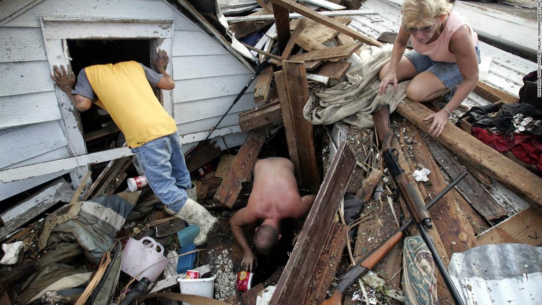 From left, Tam Cu, Jason Jackson and Linda Bryant look for belongings from Bryant&#39;s home, which was devastated in Biloxi, Mississippi.