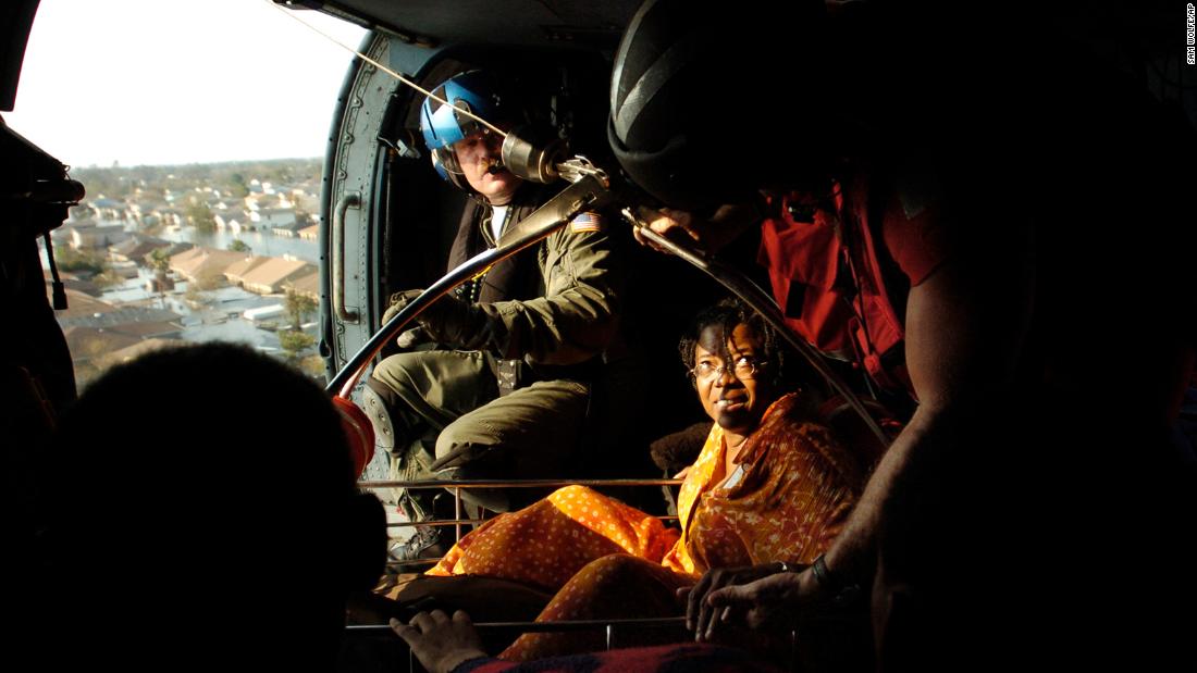Jason Jennison, an aviation survival technician with the US Coast Guard, pulls a Katrina survivor aboard a helicopter in New Orleans.