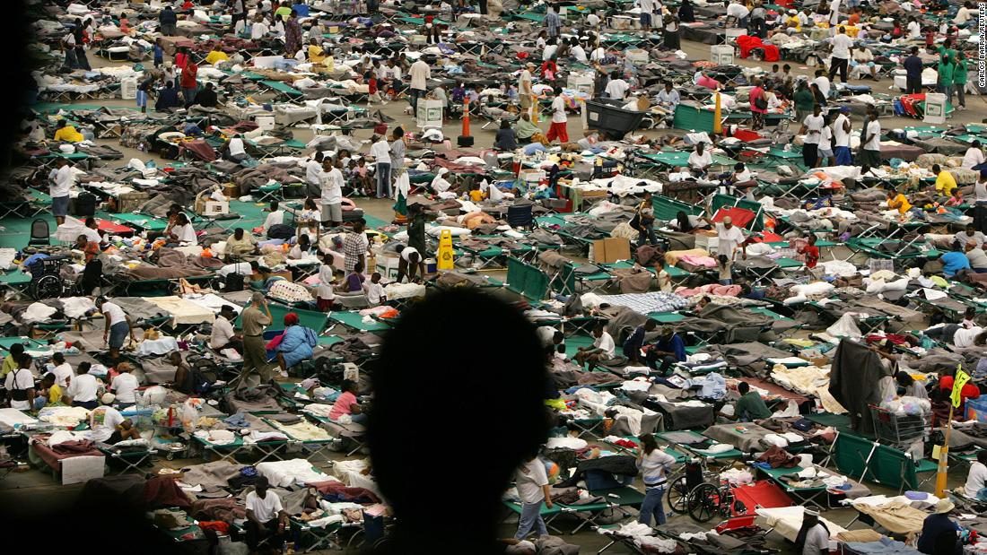A man in the foreground looks at Katrina evacuees who received food, shelter and medical attention at the Astrodome in Houston.