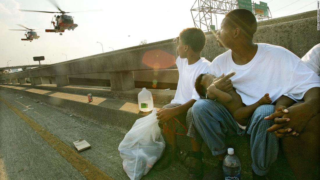 Eugene Green holds his baby, Eugene Jr., as they wait to be airlifted from a highway overpass in New Orleans on September 4, 2005.