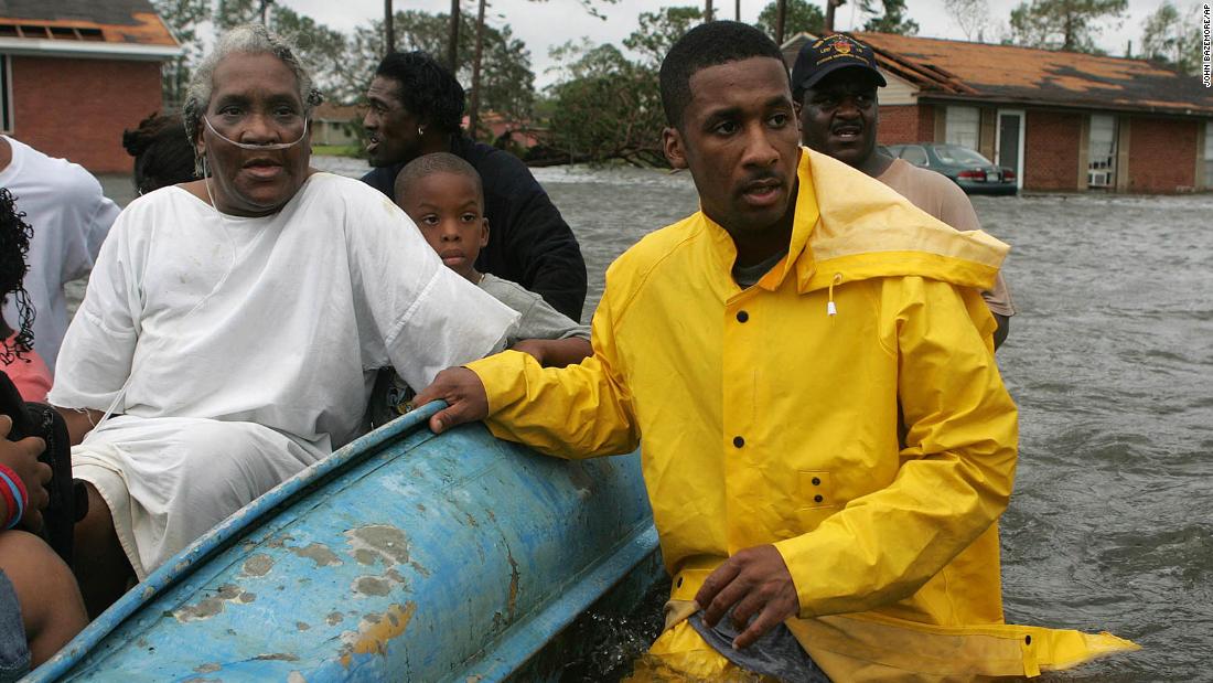 Police officer Terrence Gray helps Lovie Mae Allen and group of children evacuate their flooded homes in Gulfport, Mississippi.