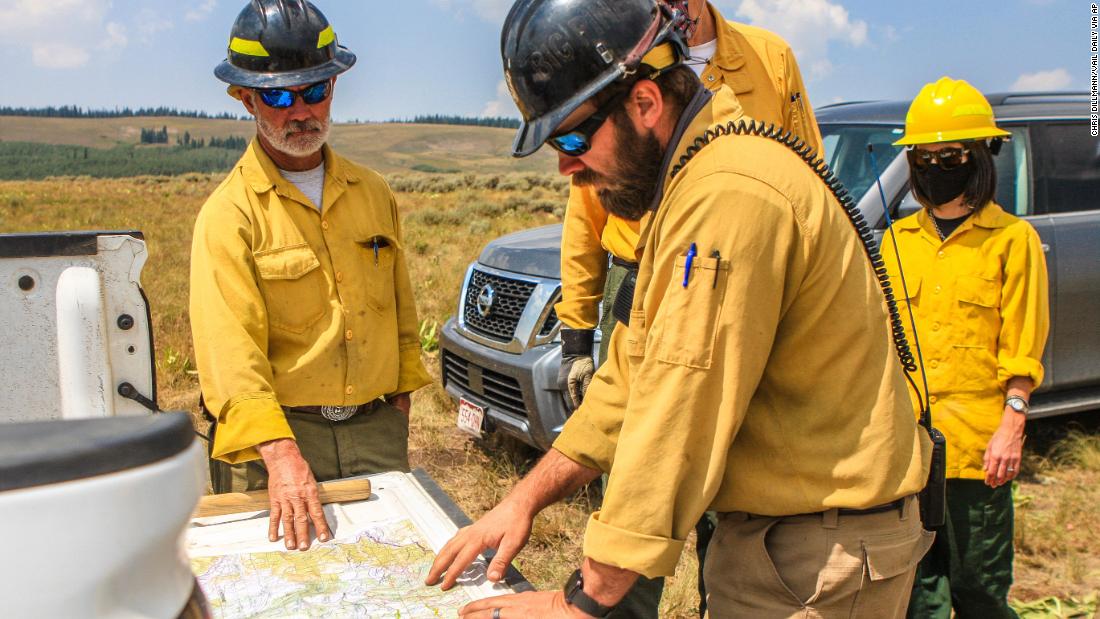 Members of the US Forest Service discuss their next moves to battle the Grizzly Creek Fire near Dotsero, Colorado, on August 21, 2020.