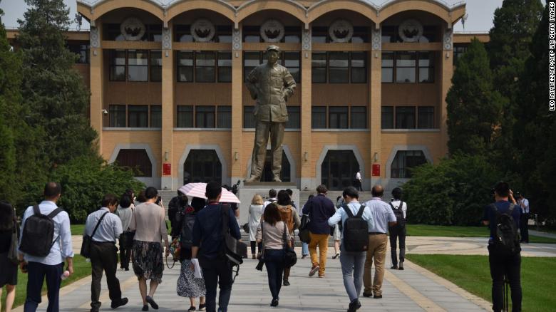 Students walk towards a statue of the late Chairman Mao Zedong at the Central Party School in Beijing.