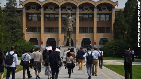 Students walk towards a statue of the late Chairman Mao Zedong at the Central Party School in Beijing.