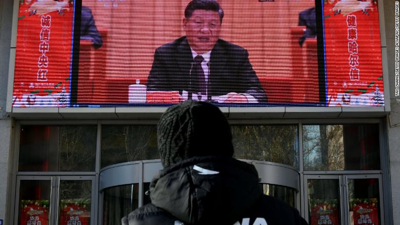 A man stands and watches a large screen during President Xi Jinping&#39;s speech commemorating the 40th anniversary of China&#39;s policy of reform and opening on December 18, 2018.