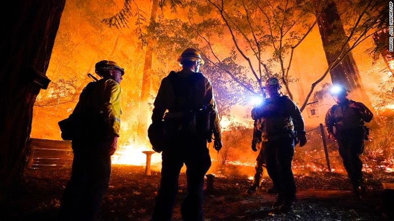 Firefighters make a stand in the backyard of a home in front of the advancing CZU August Lightning Complex Fire on Friday, August 21, in Boulder Creek, California.