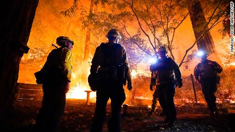 Firefighters make a stand in the backyard of a home in front of the advancing CZU August Lightning Complex Fire on Friday, August 21, in Boulder Creek, California.