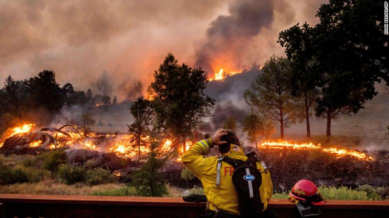 A firefighter rubs his head while watching the LNU Lightning Complex fires spread through the Berryessa Estates neighborhood of unincorporated Napa County, California, on Friday, August 21.