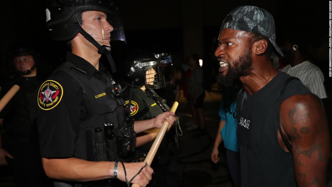 A man confronts police outside the Kenosha Police Department on August 23.