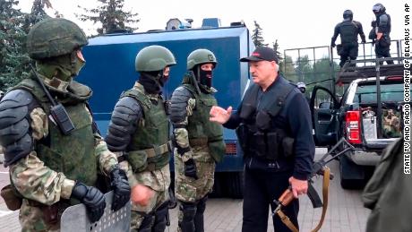 Lukashenko greets riot police near the Palace of Independence in Minsk on Sunday, in an image shown on state TV.