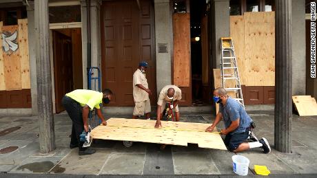 Workers board up windows in the French Quarter in anticipation of Hurricane Marco and Tropical storm Laura.