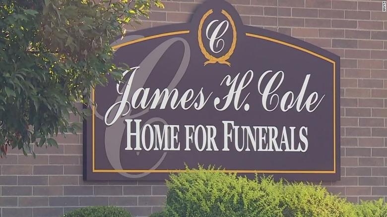 Firefighters on leave after a woman thought to be dead was found breathing at a funeral home