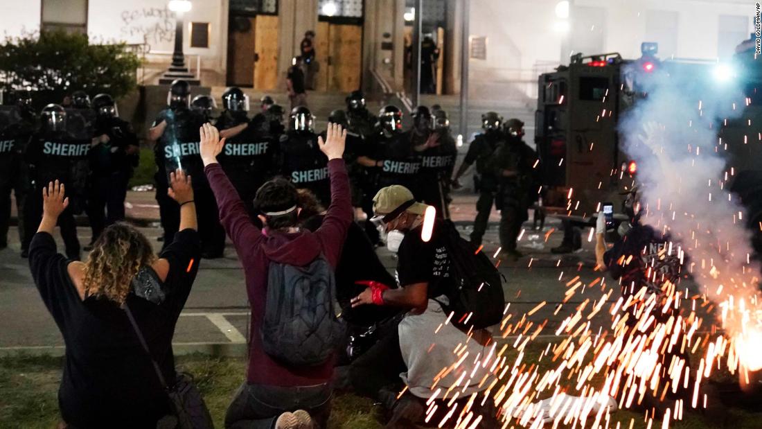 Police attempt to push back protesters outside the Kenosha County Courthouse on Monday, August 24.