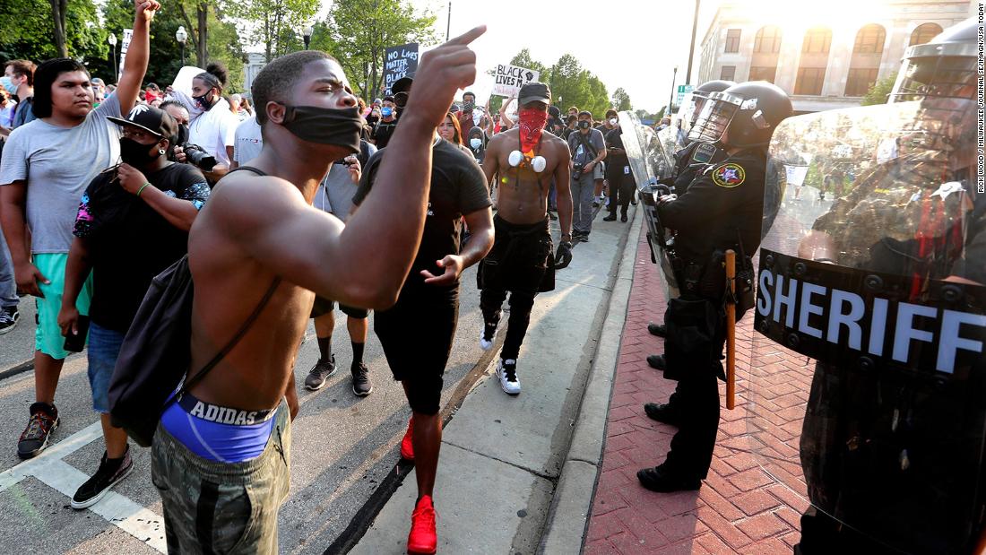 Protesters confront police officers during a march in downtown Kenosha.