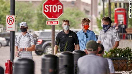 Pedestrians with face masks walk past diners in downtown Omaha, Neb., Friday, Aug. 7, 2020. (AP Photo/Nati Harnik)