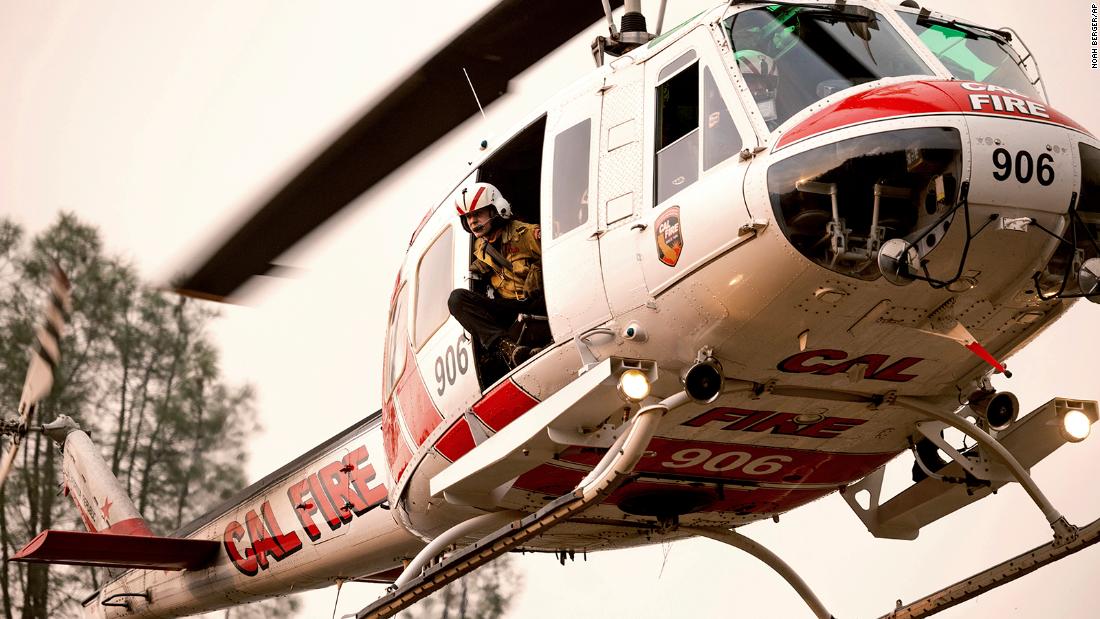 A firefighter looks out from a helicopter while battling the LNU Lightning Complex fires in Lake County, California.