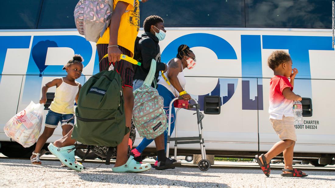 A family walks to a charter bus that would take them from Galveston Island to Austin.