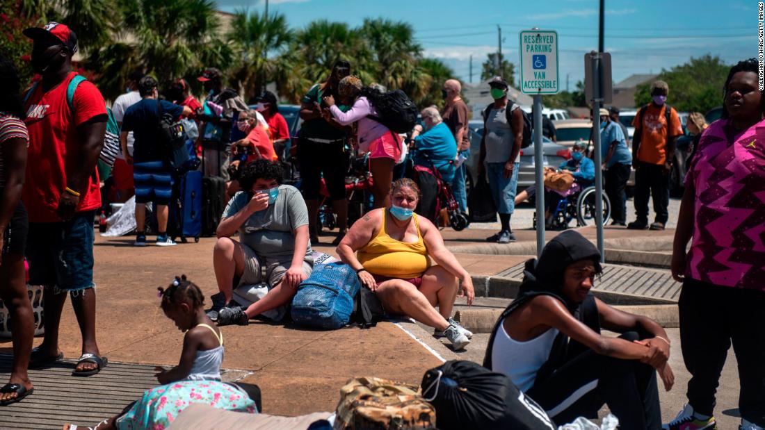 People wait to board a bus to leave Galveston.