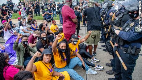 A group of demonstrators sat down in front of police during a march for Breonna Taylor in Louisville, Kentucky.