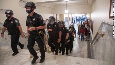 Mask-less, armed protesters stormed this state capitol building. Why?
