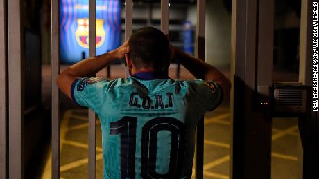 One Barcelona fan with the Greatest Of All Time on his shirt looks dejected outside the Camp Nou.