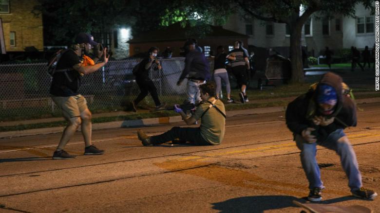 A man with a gun takes aim at another person during a third night of protests in Kenosha, Wisconsin on August 25, 2020. Police say a shooting is under investigation.