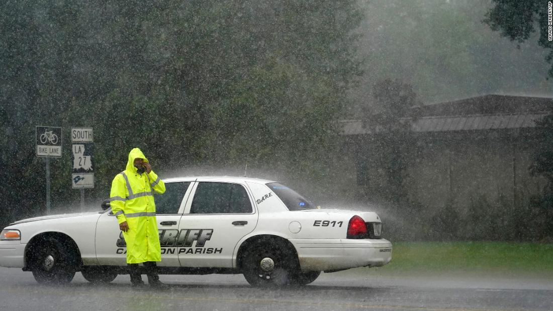 A sheriff&#39;s deputy wipes his face while manning a roadblock in Lake Charles on August 26.