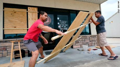 Daoith Porm, left, and Bunsant Khov, right, board their business with Hurricane Laura just hours away.