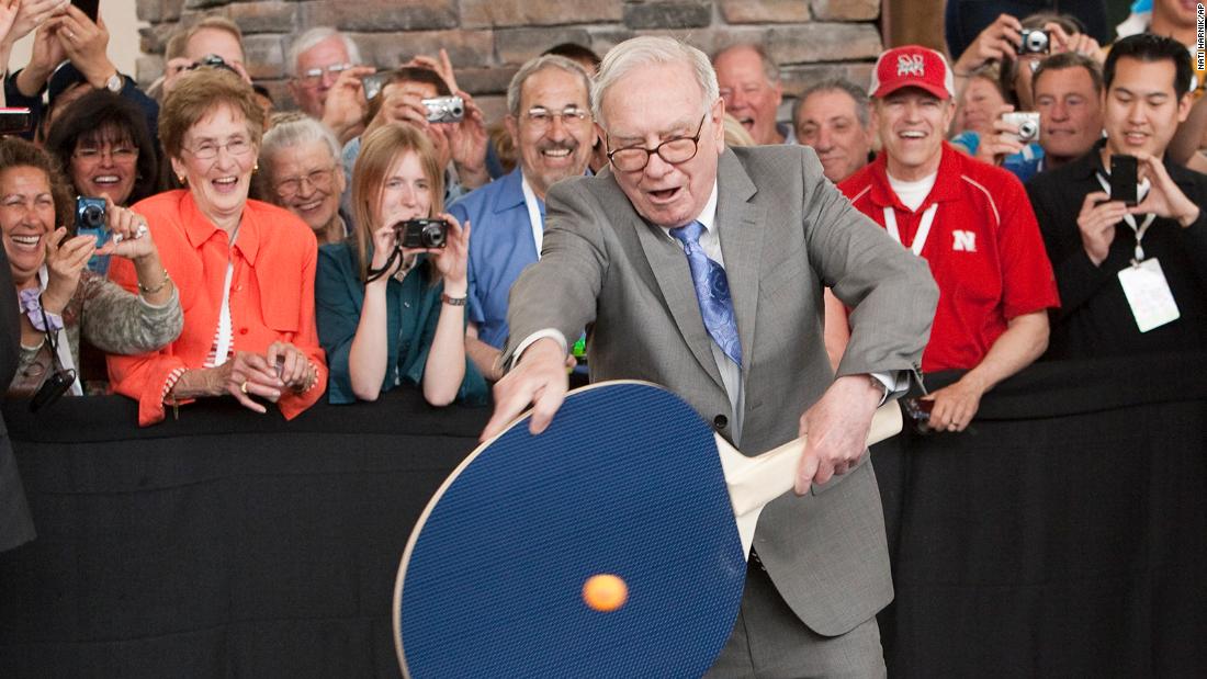 Buffett uses a large paddle to play table tennis in 2010.