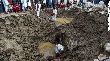 Villagers and rescuers search for bodies among debris after a flash floods in Parwan province, on August 26, 2020.