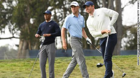 McIlroy reacts to his shot from the 12th tee at the 2020 PGA Championship in San Francisco as Thomas and Woods watch on.