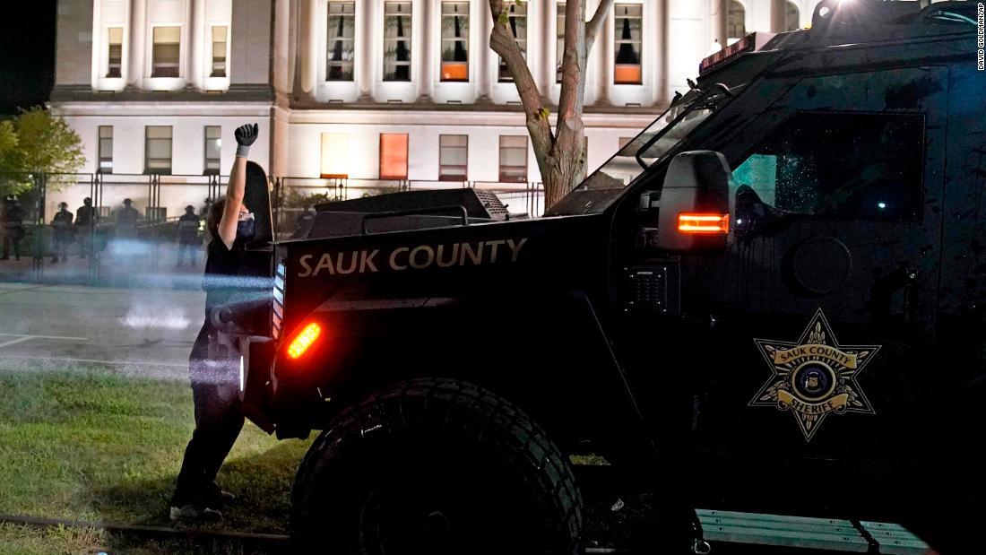 A protester obstructs an armored vehicle outside the Kenosha County Courthouse.