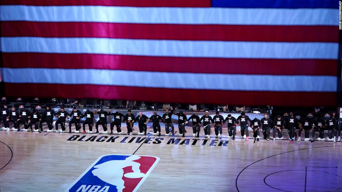 Members of the Orlando Magic and Brooklyn Nets kneel during the National Anthem before the start of an NBA game on July 31.