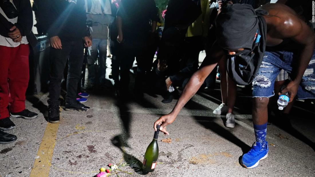 A protester places a bottle at the scene where &lt;a href=&quot;https://www.cnn.com/2020/08/26/us/kenosha-wisconsin-wednesday-shooting/index.html&quot; target=&quot;_blank&quot;&gt;a person was fatally shot during demonstrations&lt;/a&gt; the night before.