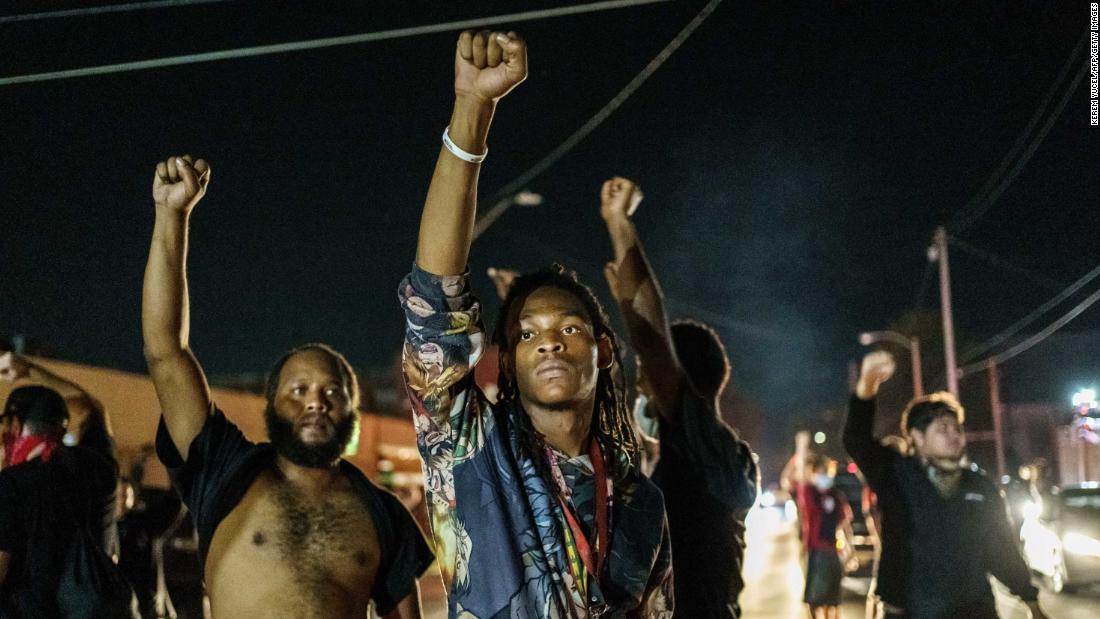 Protesters raise their fists during a demonstration in Kenosha on August 26.