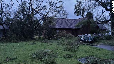 Downed trees litter the yard of a home in Sulphur, Louisiana.