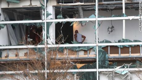 A person is seen through the blown out windows of the Capitol One Bank Tower in the downtown area of Lake Charles on Thursday.