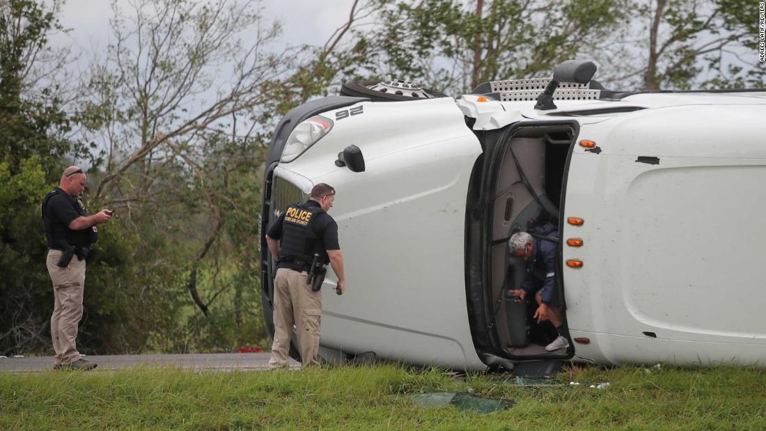 The driver of an overturned 18-wheeler exits his vehicle after police arrive to the scene along Interstate 10 in Vinton, Texas. Both the driver and a passenger suffered minor injuries.
