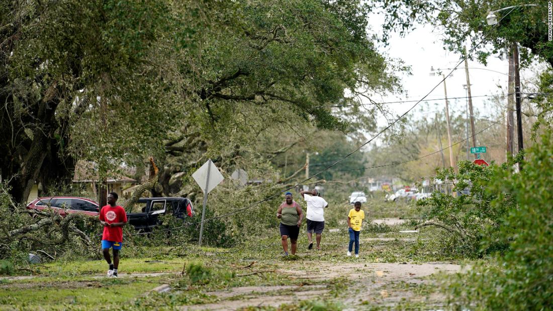 People survey the damage to their Lake Charles neighborhood on August 27.