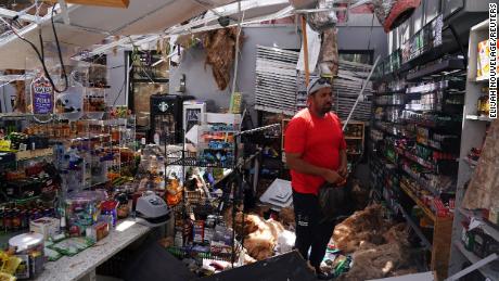 Ahmed Nawaz examines the damage to his store following Hurricane Laura in Lake Charles, Louisiana.