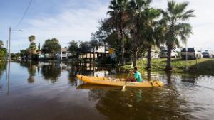 Martin Almanza paddles a canoe through some street flooding following landfall of Hurricane Laura on Thursday, Aug. 27, 2020 in Galveston, Texas. (Brett Coomer/Houston Chronicle via AP)