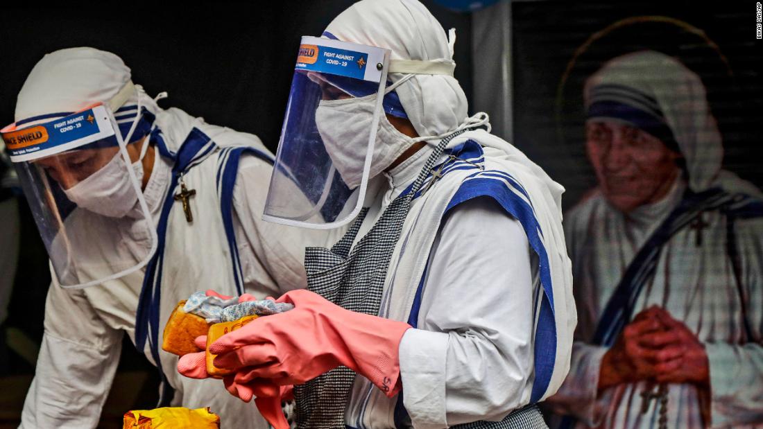 Nuns of the Missionaries of Charity, the order founded by Mother Teresa, wear masks and face shields as they distribute food to the poor and homeless in Kolkata, India, on August 26.