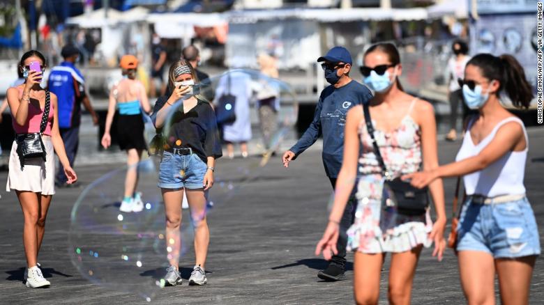 People wearing face masks stroll in the old harbour of Marseille on Wednesday.