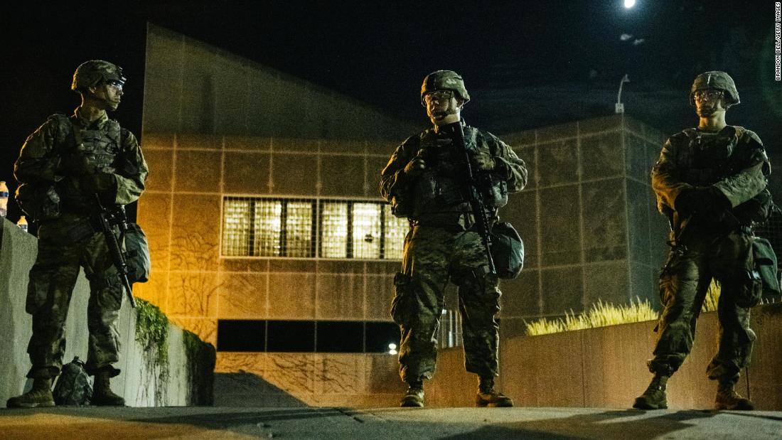 Members of the National Guard stand inside a fenced area surrounding government buildings on August 27.