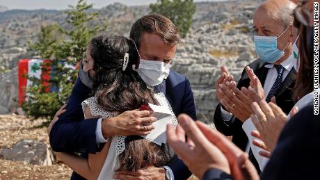 The French President hugs a blast victim while attending a ceremony, with French Foreign Minister Jean-Yves Le Drian (right) to mark Lebanon&#39;s centenary in Jaj Cedars Reserve Forest, northeast of Beirut, on September 1.